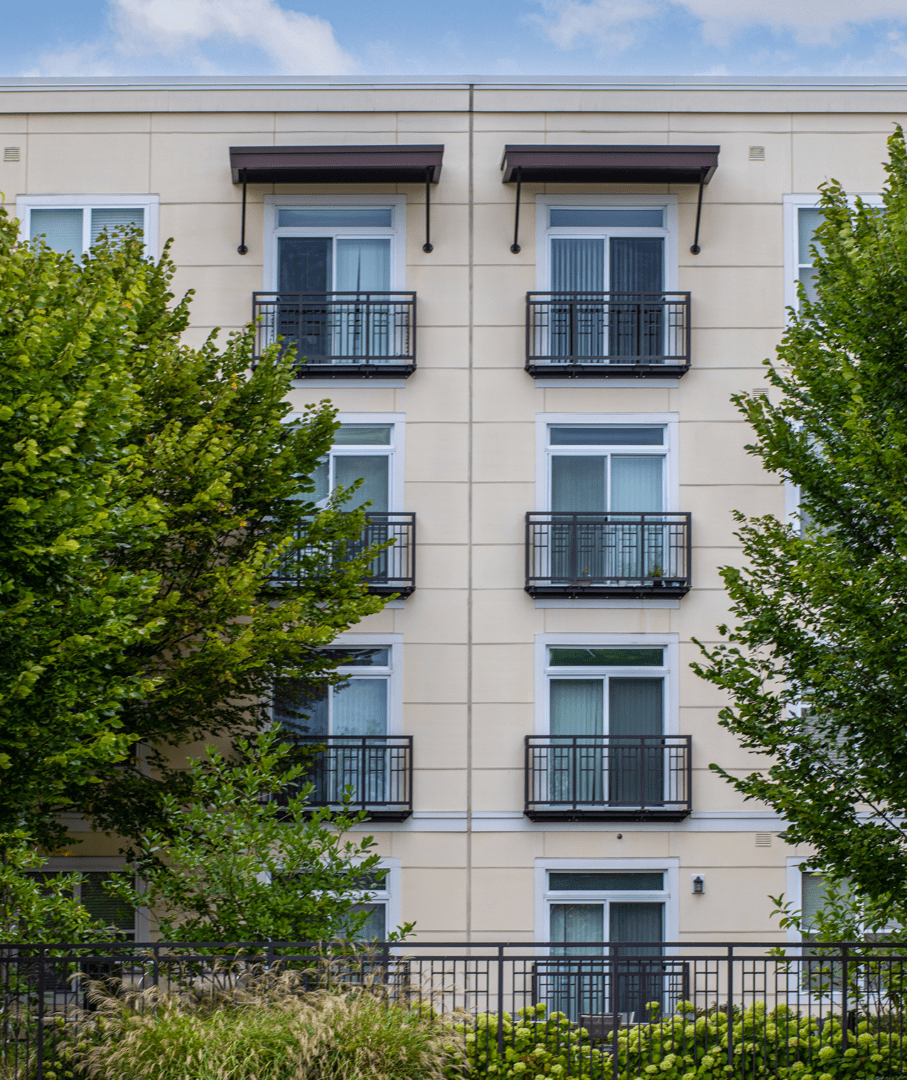GettyImages-1344167029 Apartment building with balconies and trees.
