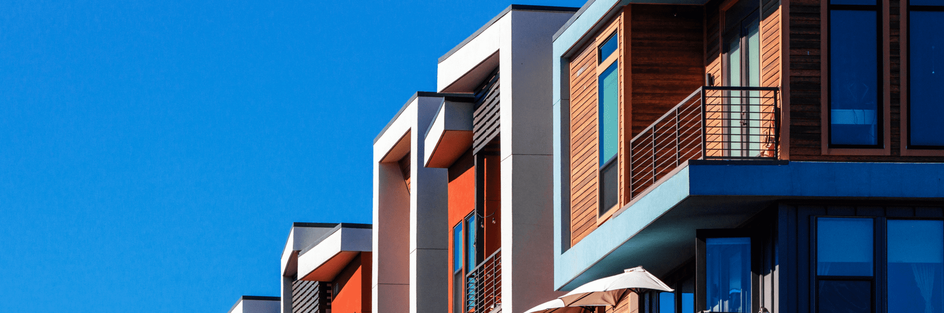 GettyImages-1925865357 Modern apartment building with blue sky background.