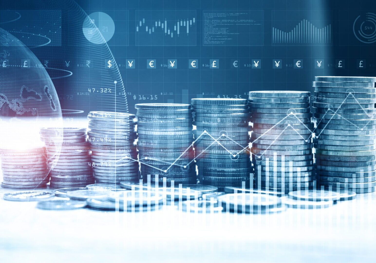 A blurry photo of stacks of coins with graphs in the background.
