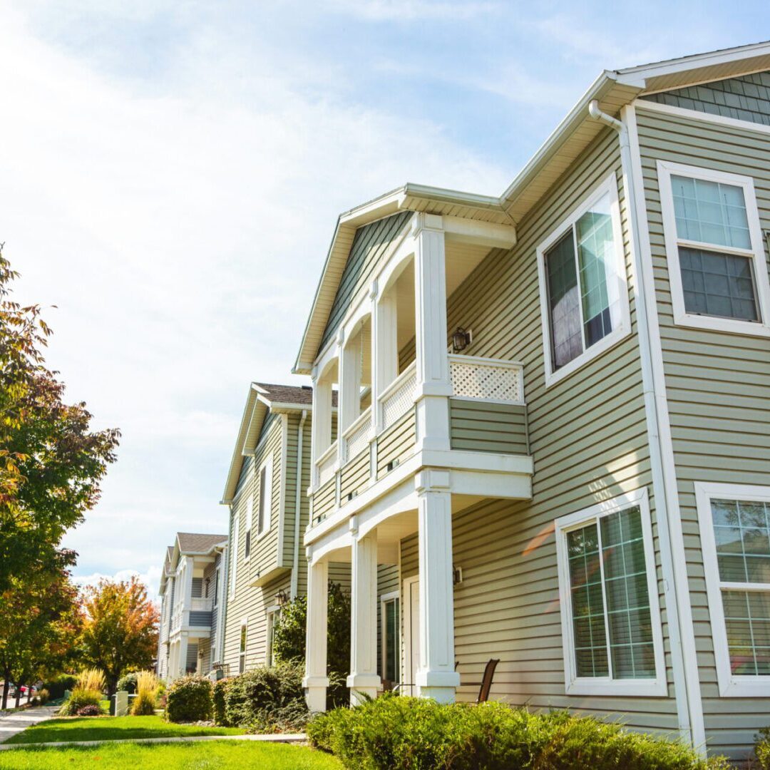 A row of houses with trees in the background.